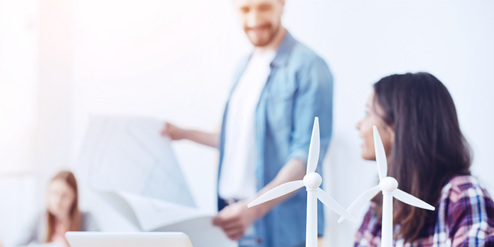 Two people behind models of wind generators.