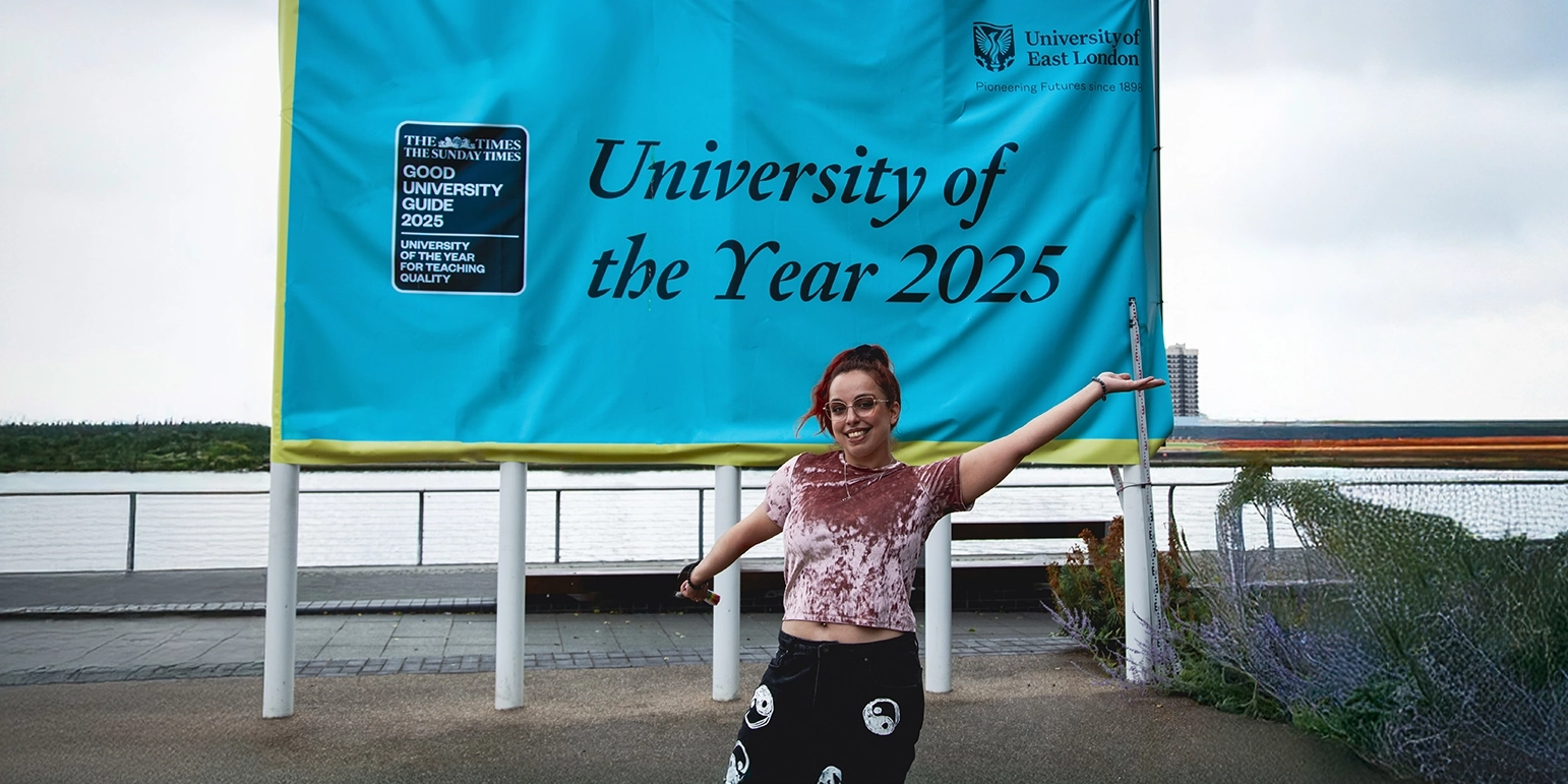 UEL student poses in front of University of the Year sign
