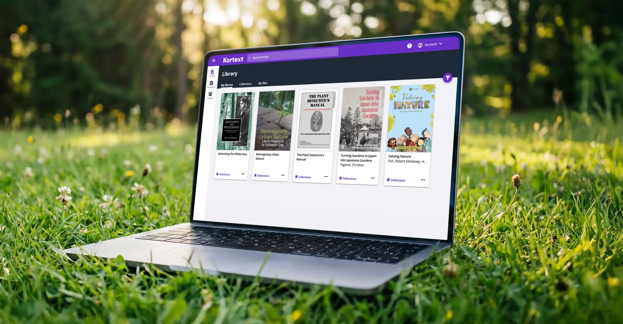 Kortext bookshelf displayed on a laptop screen, surrounded by grass and trees, showing a collection of nature-themed digital textbooks.