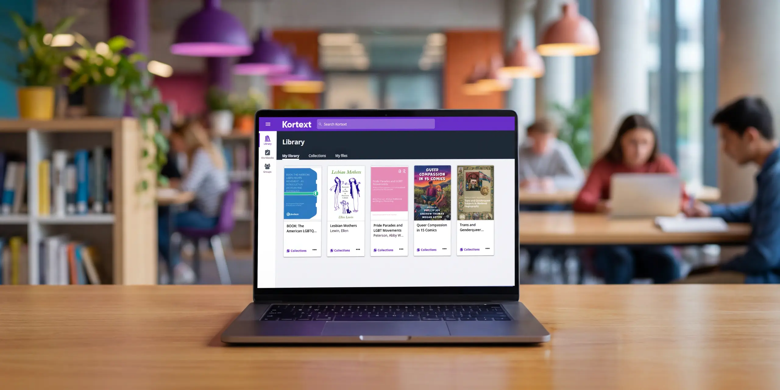 A laptop, in an academic library, displaying the Kortext library platform showing five LGBTQ+ open access titles.