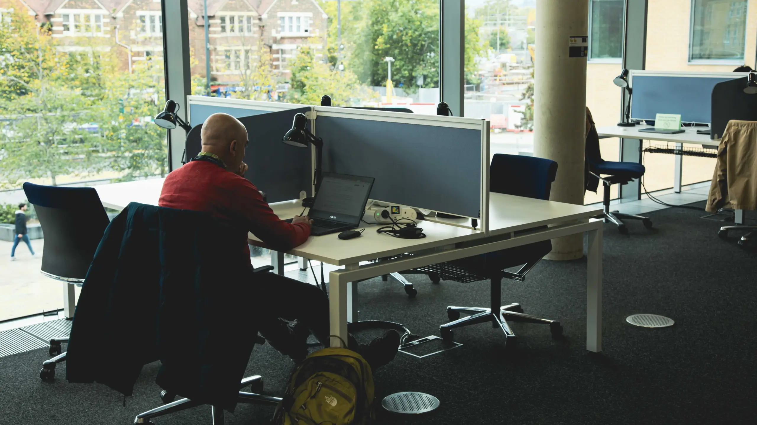 A student working at a laptop in a bright, open-plan study space at Saïd Business School.