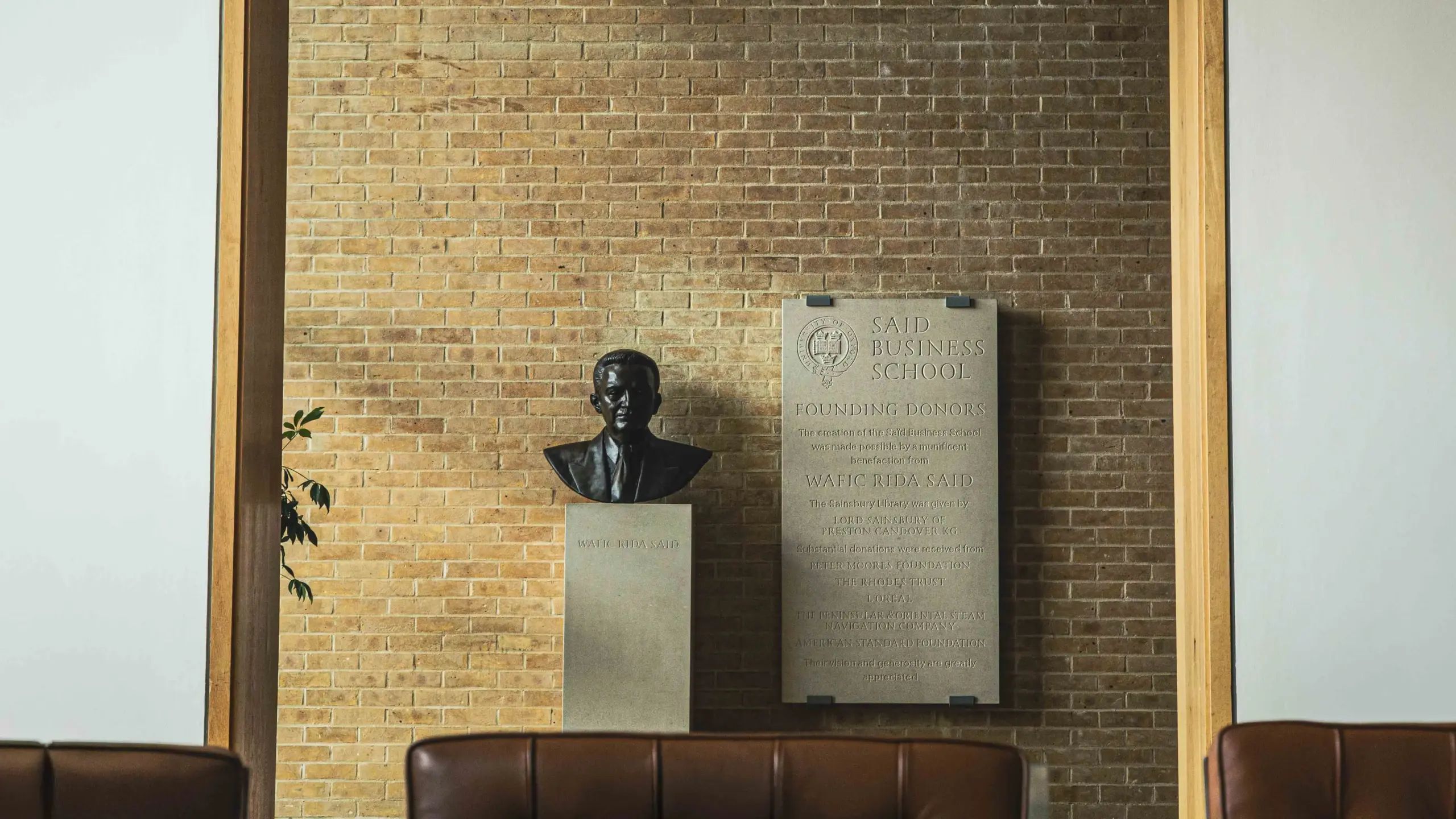 A bronze bust of Wafic Rida Said mounted on a plinth inside Saïd Business School, alongside a stone founding donors plaque.