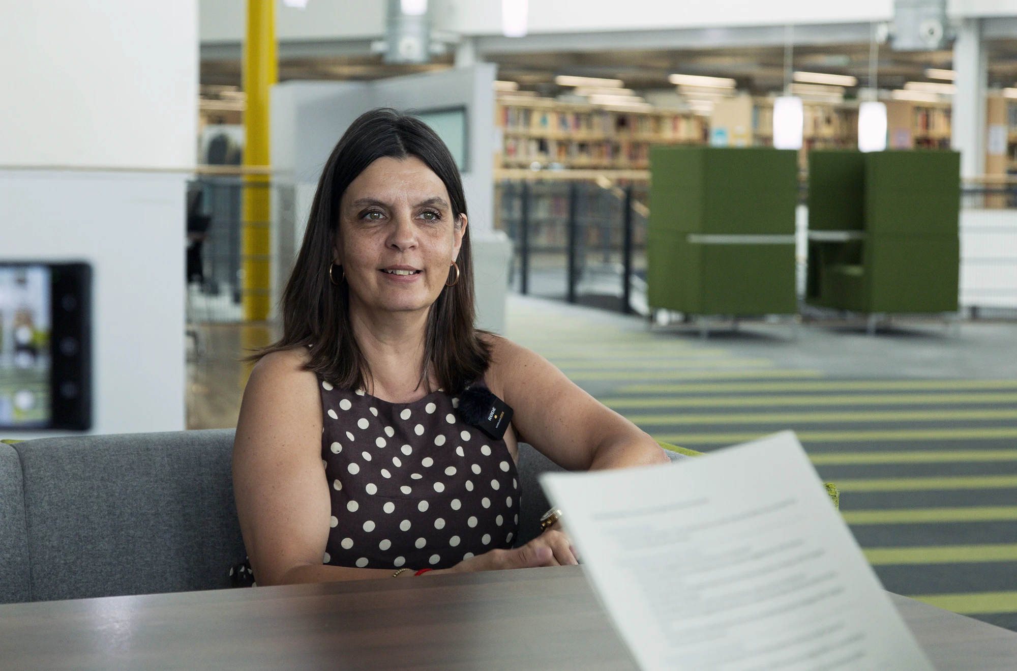 Cheryl Harris, from the UEL content and digital team, sitting at a table in the library being interviewed