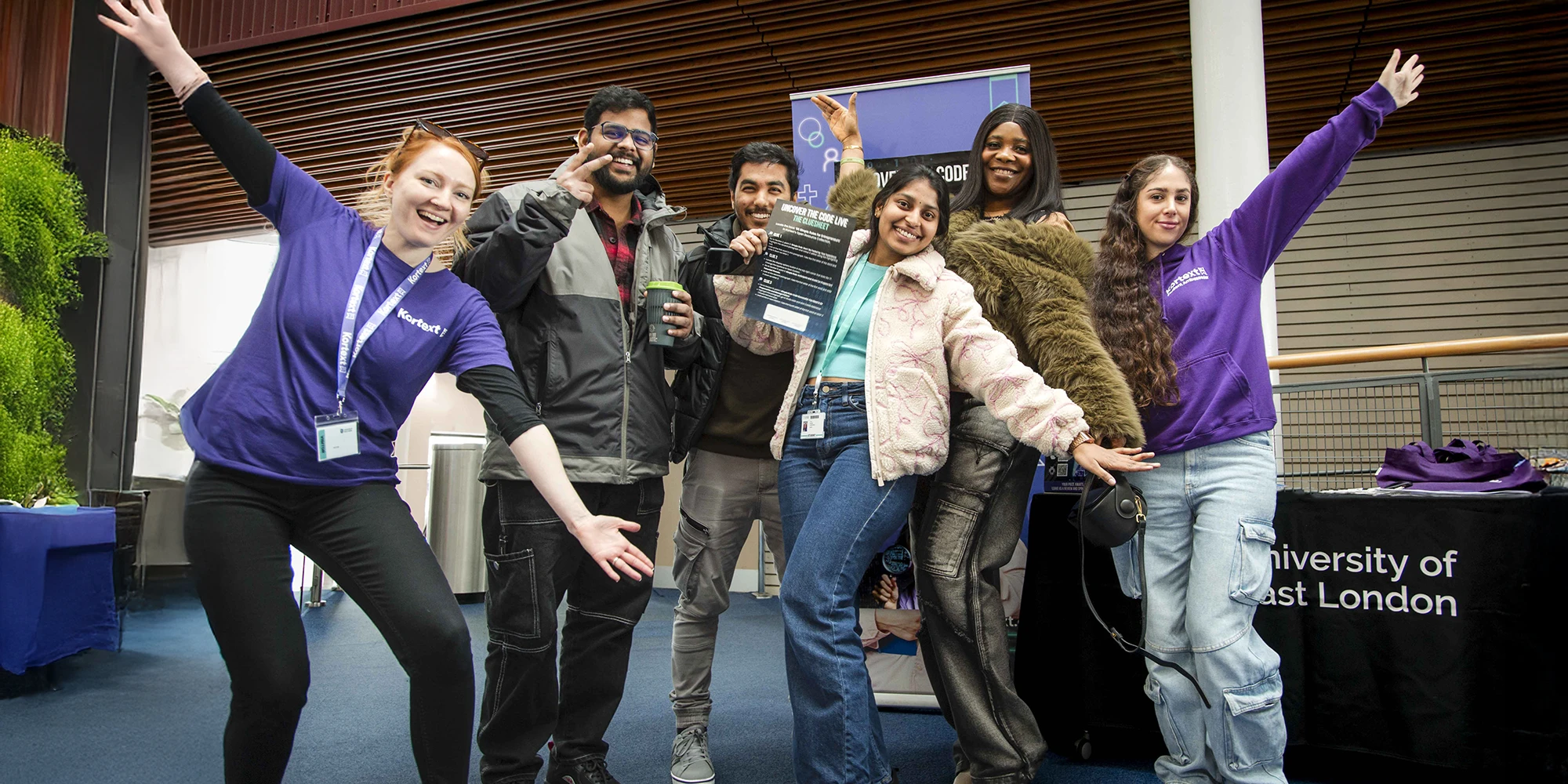 Kortext team member, student ambassador and students posing at a UEL event stand