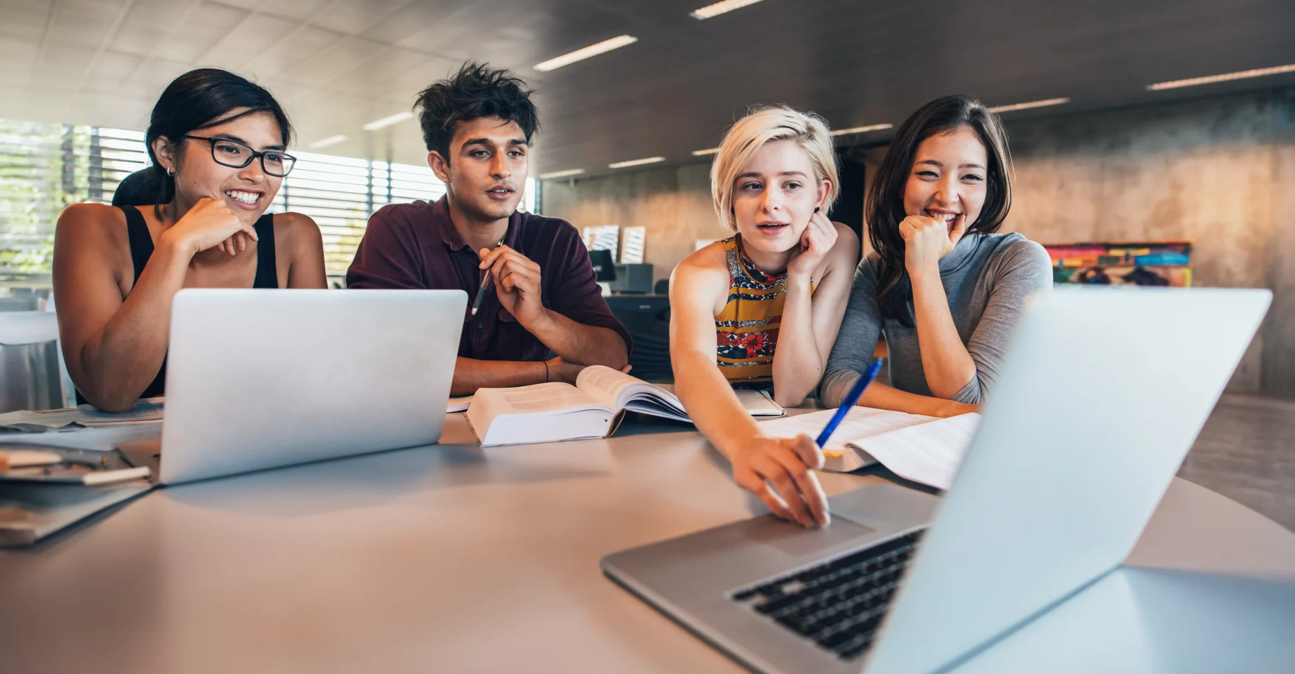 A group of young people using a laptop to study.