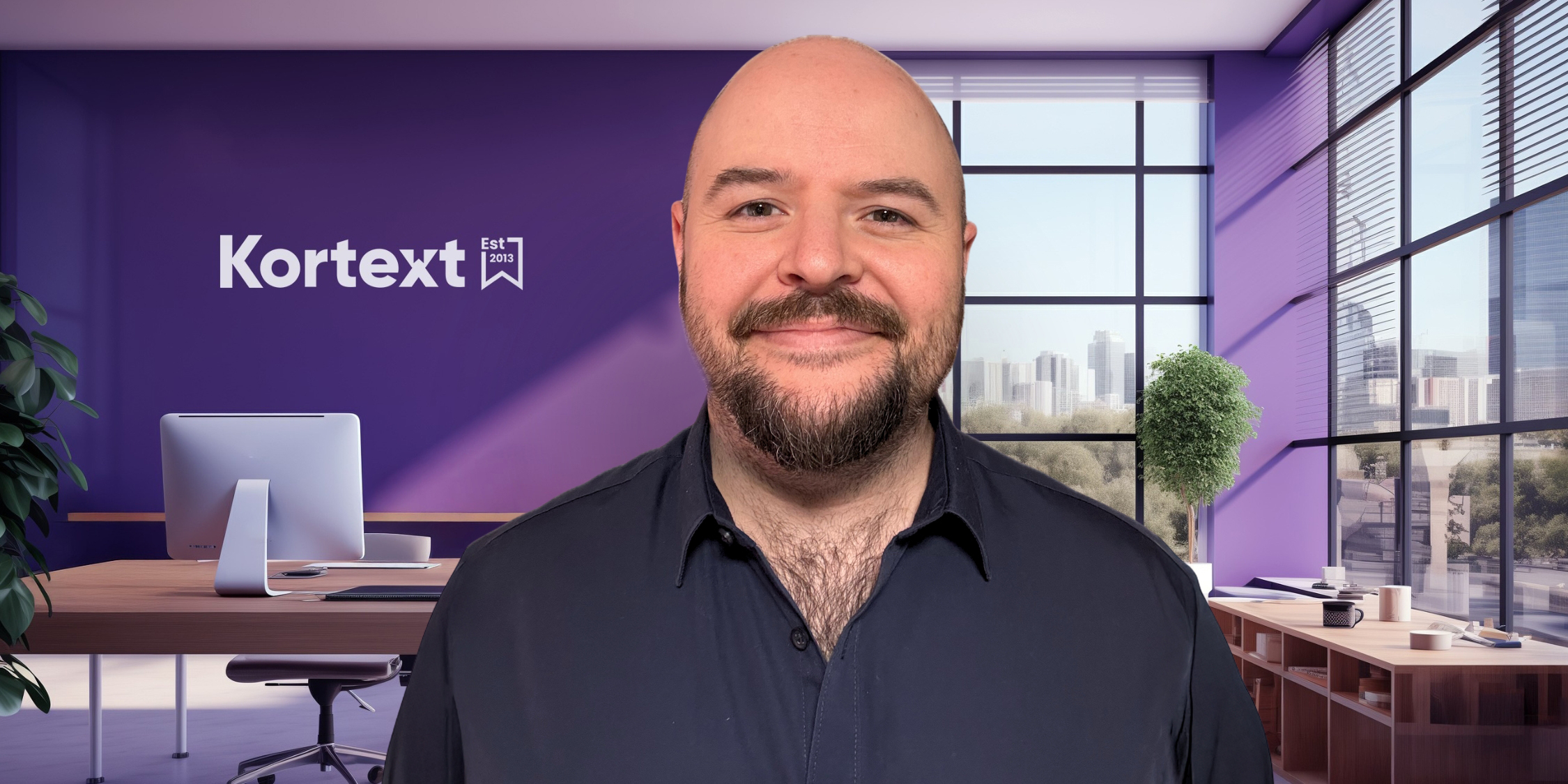 Image shows Joel Hewitt, a white man with a beard who is wearing a dark coloured shirt. Joel is standing against a Kortext-branded background.