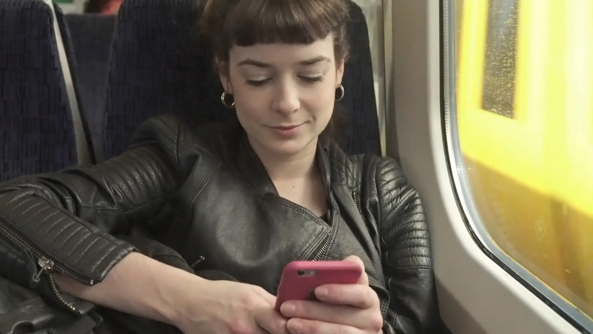 student on train looking at phone