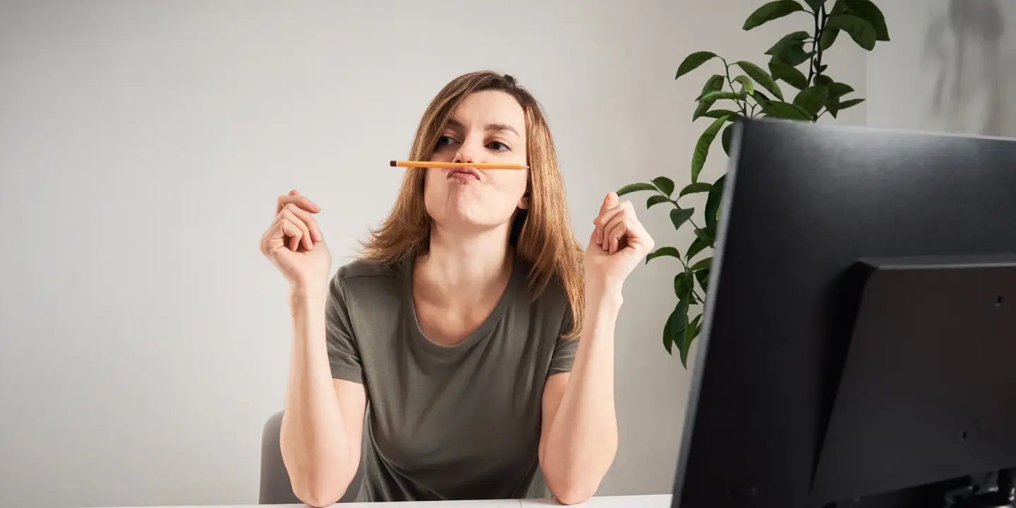 Woman balancing pencil on face